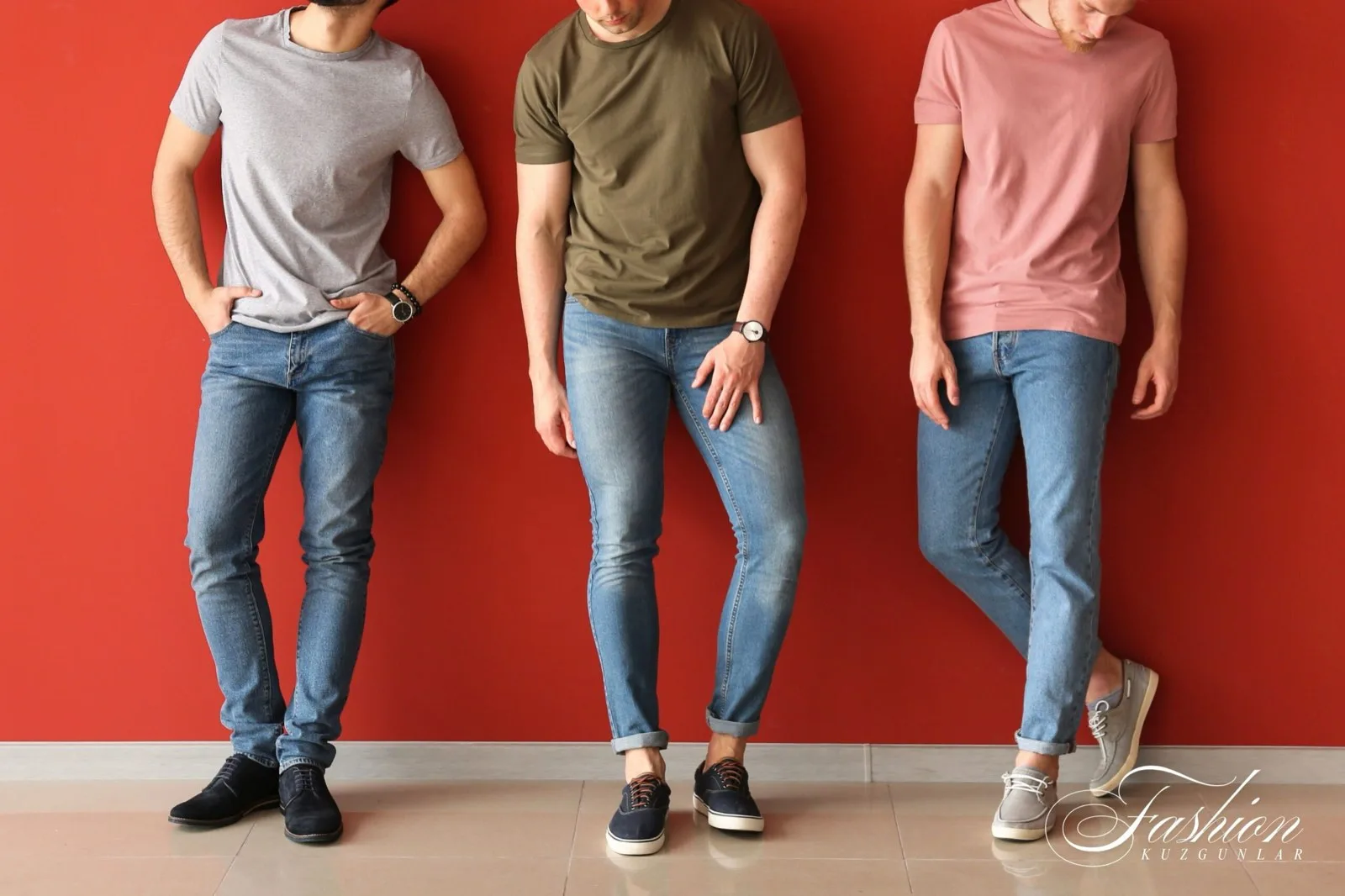Kırmızı duvar önünde açık yıkama slim kot giyen üç erkek